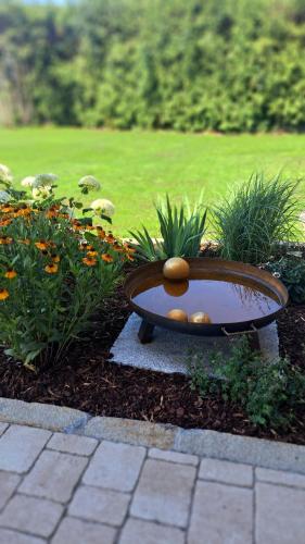 a bird bath in a garden with flowers at Ferienwohnung z'Dandlberg in Tittmoning