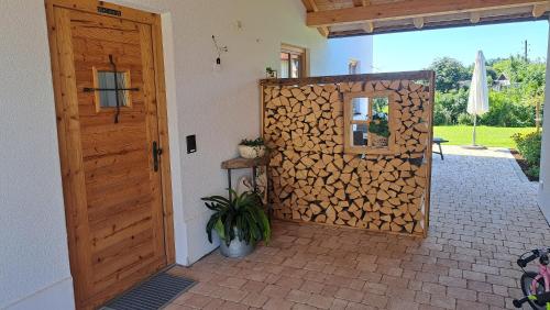 a wooden door with a wall of fire wood at Ferienwohnung z'Dandlberg in Tittmoning