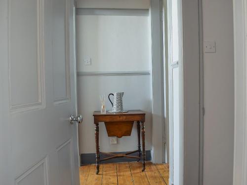 a hallway with a small table and a door at St Andrews in Pittenweem