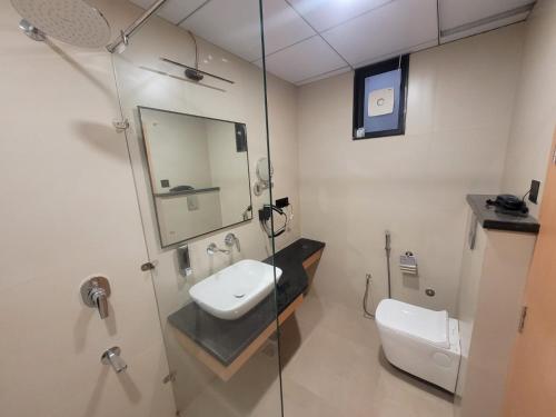 a bathroom with a toilet and a sink and a mirror at Nirvana Nest in Lucknow