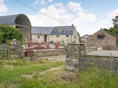 an old building with graffiti on the side of it at The Milking Parlour in Llangeler