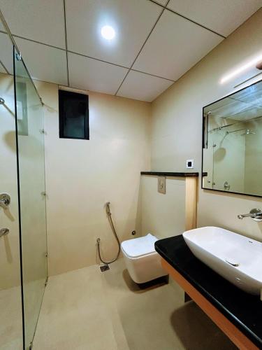 a bathroom with a toilet and a sink and a shower at Nirvana Nest in Lucknow
