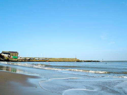a beach with the ocean and a pier in the background at The Milking Parlour in Llangeler