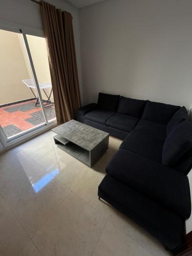 a living room with a black couch and a table at La Casa Luminosa 3 in Larache
