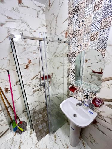 a bathroom with a sink and a glass shower at La Casa Luminosa 3 in Larache