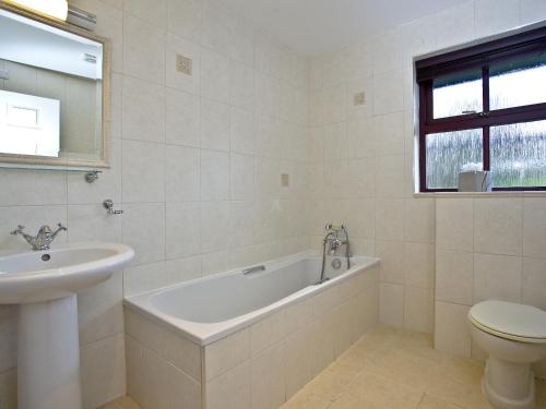 a bathroom with a tub and a sink and a toilet at Holly in Saint Wenn