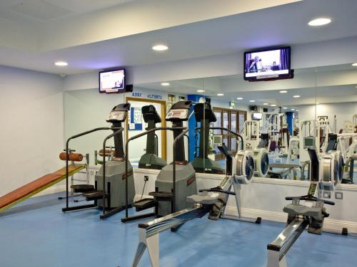a gym with treadmills and machines in a room at Holly in Saint Wenn