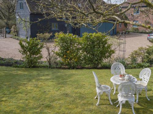 two chairs and a table in a yard at Woolhouse Barn in Hunton