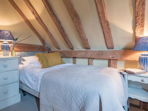 a bedroom with a bed and a desk with two lamps at Woolhouse Barn in Hunton