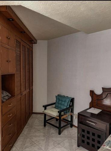 a bedroom with a chair and a bed and a dresser at HOMS - Ubicación inigualable - Hospédate como en casa in Sofía