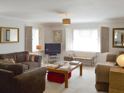 a living room with two couches and a coffee table at Trelawny Court in Saint Minver