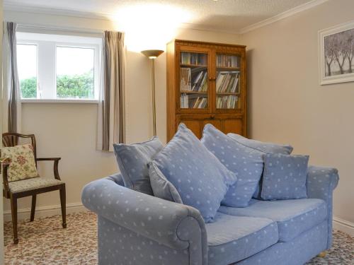 a blue couch with blue pillows in a living room at Lorna's At The Grange - Uk11565 in Mockerkin