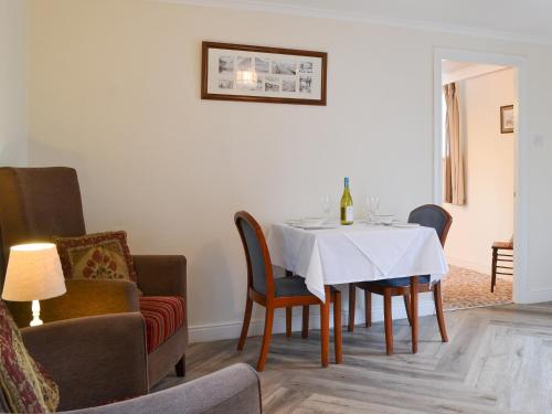 a dining room with a white table and chairs at Lorna's At The Grange - Uk11565 in Mockerkin