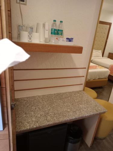 a room with a counter with bottles on a shelf at Ginger Surat City Centre in Surat