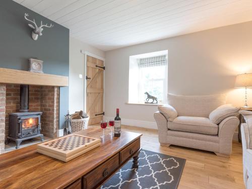 a living room with a couch and a fireplace at Abraham's Cottage in Low Eskcleth