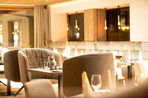 a restaurant with chairs and tables in a room at Hotel Elisabeth, 4 Sterne Superior in Kirchberg in Tirol
