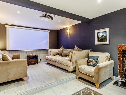 a living room with two couches and a projection screen at The Golden Crown in Tarbolton