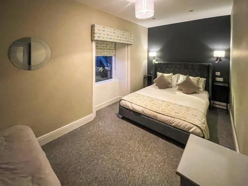 a hotel room with a bed and a window at The Golden Crown in Tarbolton