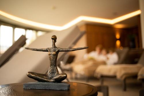a metal statue of a woman sitting on a table at Hotel Elisabeth, 4 Sterne Superior in Kirchberg in Tirol