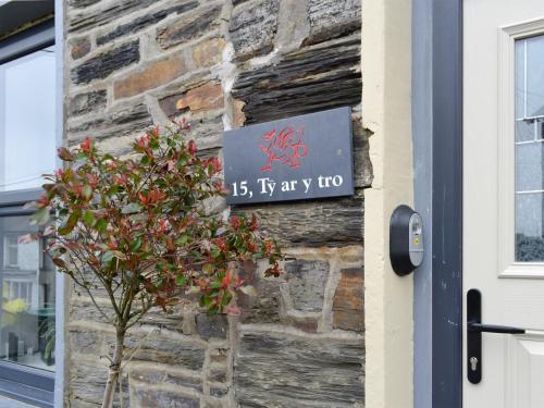 a sign on the side of a building next to a tree at Tŷ Ar Y Tro in Tanygrisiau