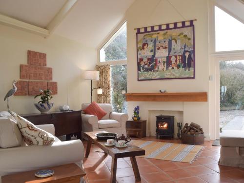 ein Wohnzimmer mit Couch und Kamin in der Unterkunft Tucking Cottage in Treffgarne