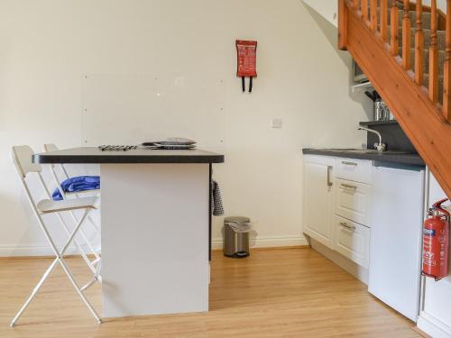 eine Küche mit Theke und Tisch in einem Raum in der Unterkunft Bunker - Uk11039 in Carlyon Bay