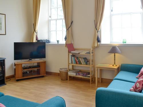 a living room with a couch and a tv at Cloud Howe in Arbuthnott