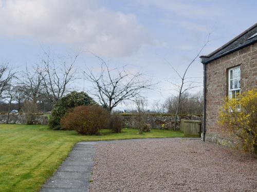a brick house with a garden and a yard at Cloud Howe in Arbuthnott