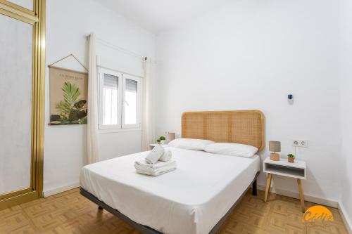 a bedroom with a large bed with white sheets at Garcia Rooms by Cadiz Time in Cádiz