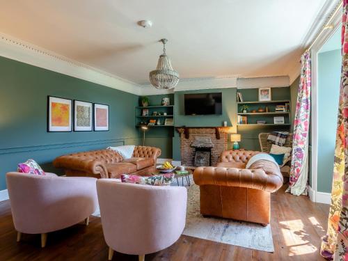 a living room with leather furniture and a fireplace at The Retreat - M in Burton Bradstock