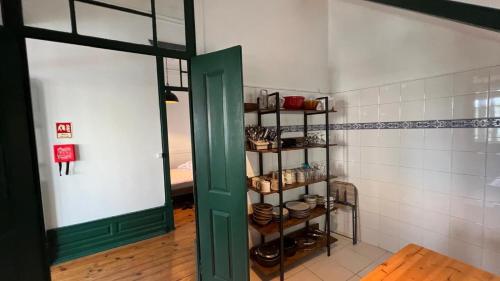 a room with a green door and shelves with pots and pans at Jugendstil Villa - 2 min zum Meer in Figueira da Foz