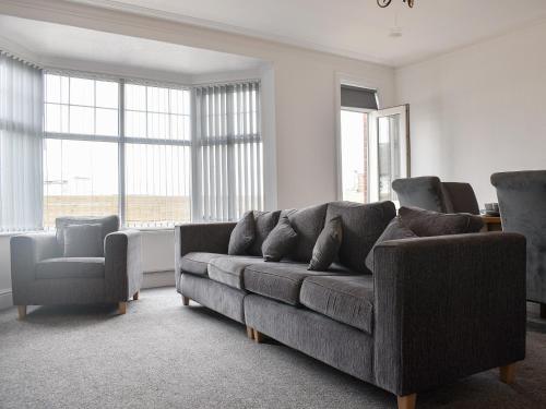 una sala de estar con un sofá y dos sillas en South Side - Apartment, en Bridlington