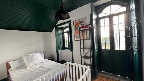 a bedroom with a white bed and a green door at Jugendstil Villa - 2 min zum Meer in Figueira da Foz