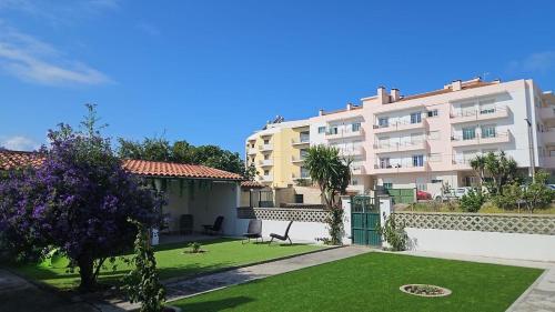 a large apartment building with a lawn in front of it at Jugendstil Villa - 2 min zum Meer in Figueira da Foz