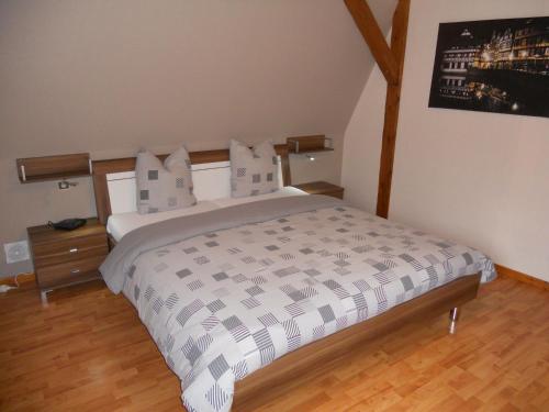 a bedroom with a large bed and a wooden floor at Das Ferienhaus Caspar Für 2 Bis 4 Personen in Obernai