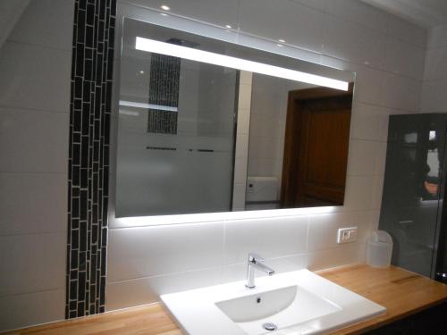 a bathroom with a sink and a mirror at Das Ferienhaus Caspar Für 2 Bis 4 Personen in Obernai