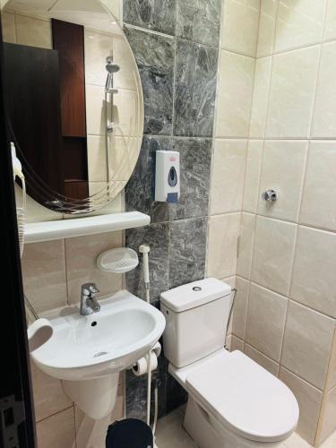 a bathroom with a toilet and a sink and a mirror at Alzaer Almutamyez Ajyad in Mecca