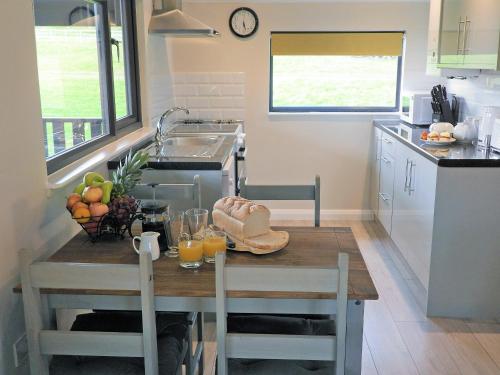 a kitchen with a table with a bowl of fruit and juice at Primrose Lodge - Uk13447 in Halwill