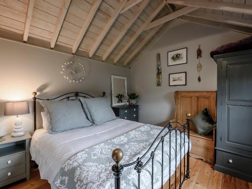 a bedroom with a bed and a wooden ceiling at Brook Farm Annex in Tenterden