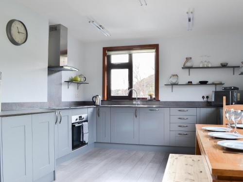 a kitchen with white cabinets and a sink at Cuckoos Nest in Cove