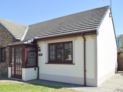 a small white house with a large window at Pembroke Cottage in Pembroke