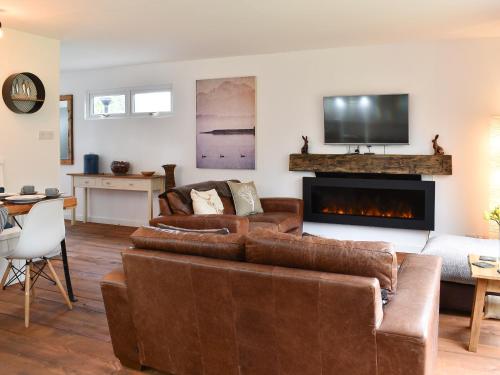 Una sala de estar con un sofá y una chimenea. en The Wood House, en Buckfastleigh