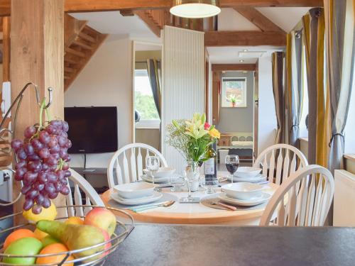 a dining room with a table with a bowl of fruit at The Chapel Barn in Llangynllo