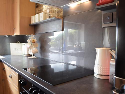 a kitchen with a sink and a stove top oven at The Chapel Barn in Llangynllo