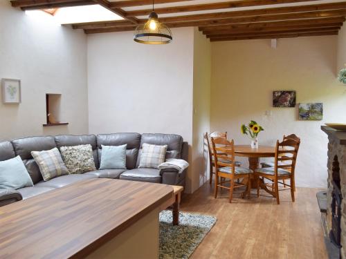 a living room with a couch and a table at Old Rectory Cottage - Dinas Country Club in Dinas