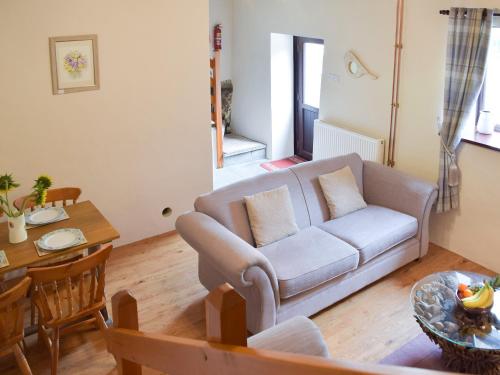 a living room with a couch and a table at Hay Barn - Dinas Country Club in Dinas