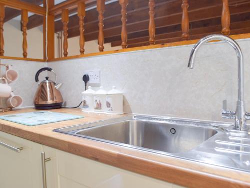 a kitchen counter with a stainless steel sink at Hay Barn - Dinas Country Club in Dinas