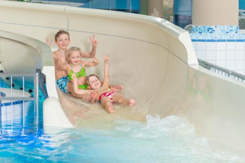 a group of children playing on a water slide in a pool at FerienResidenz MüritzPark in Röbel