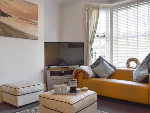 a living room with a couch and a tv at Driftwood in Scarborough