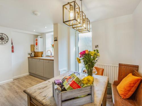 una cucina con un tavolo con un vaso di fiori di Hillside Cottage a Haltwhistle